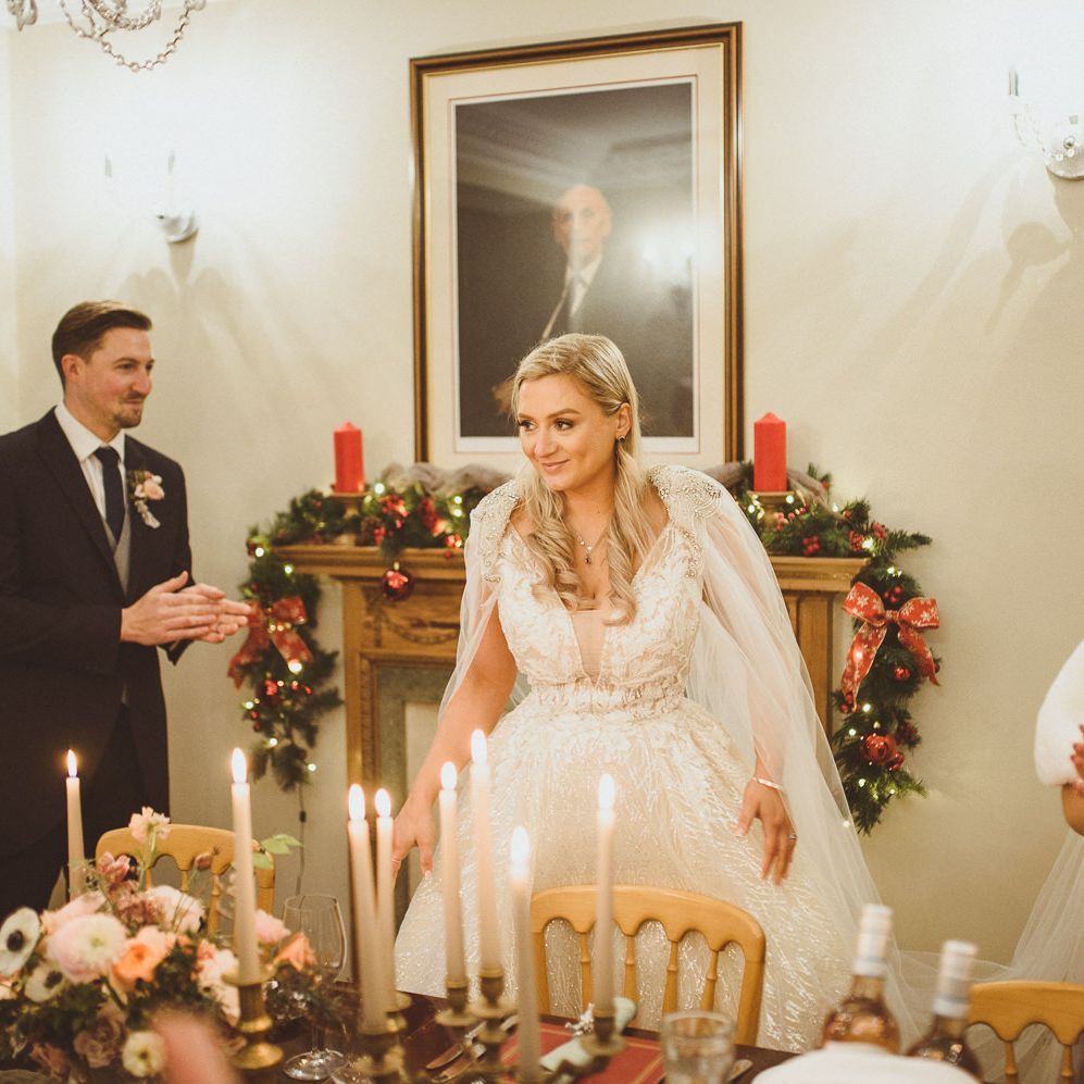 Beautiful bride in a Enzoani wedding dress and bespoke bridal cape at Goldsborough Hall wedding reception