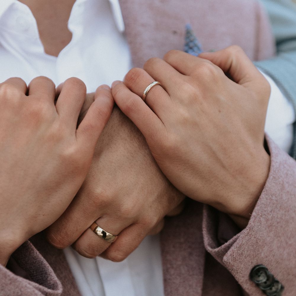 Grooms embrace outdoors whilst wearing pastel suits