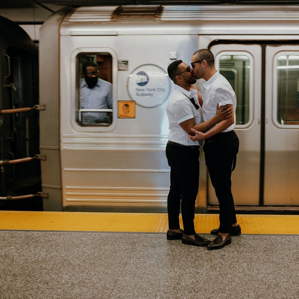 Grooms kiss on the subway at New York wedding