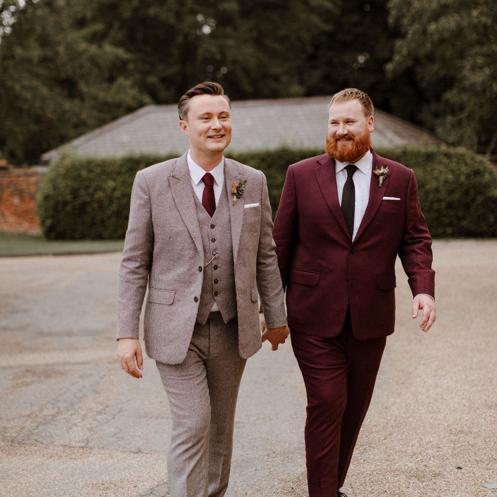 Two groom in in check and burgundy suits at orangery wedding 