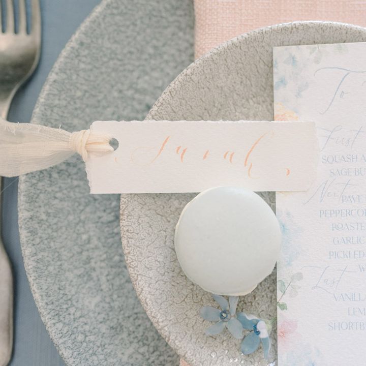 Place setting with on the day menu card and blue macaroon wedding favour 