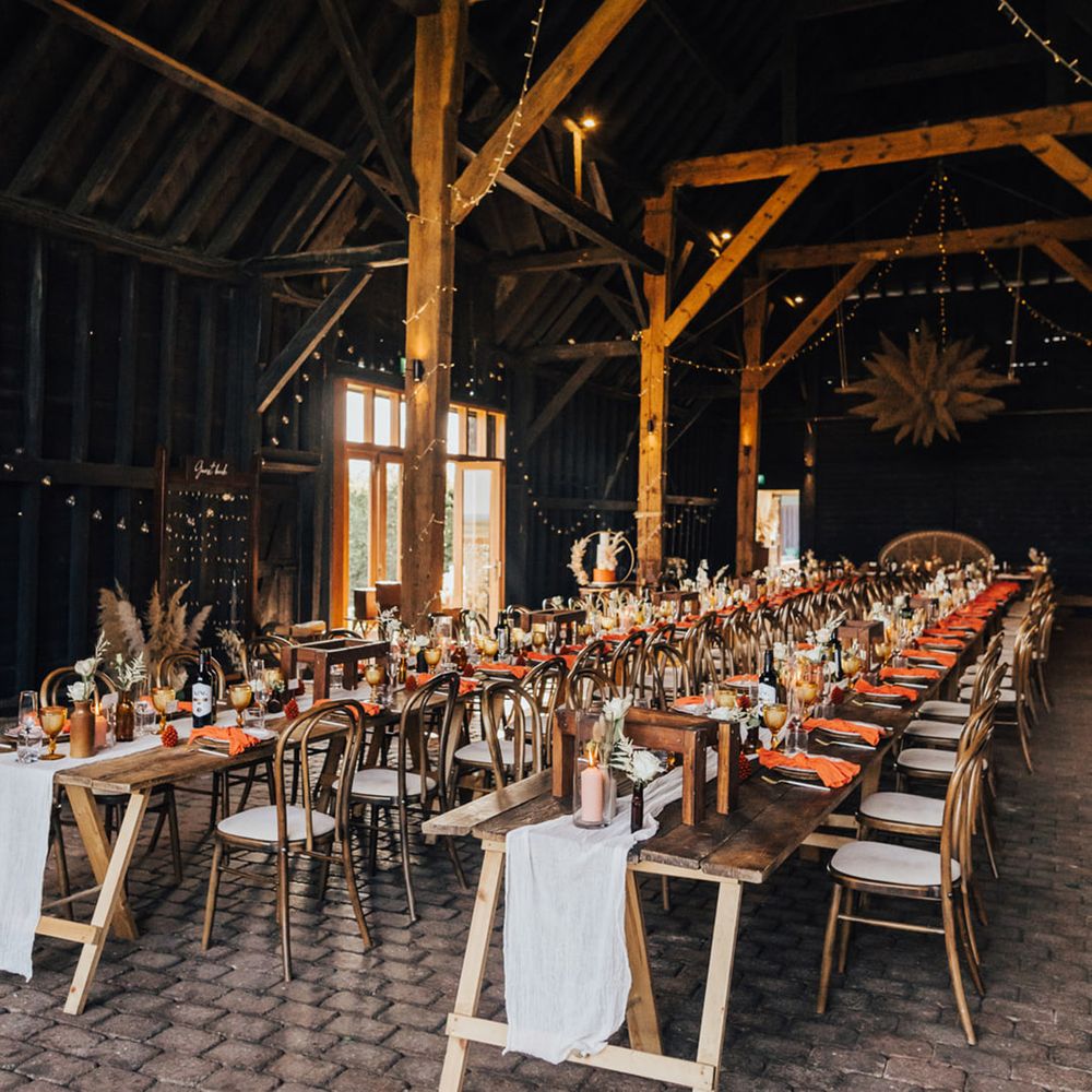 Fairy lights, pampas grass, autumnal colour dinner place settings at Boho wedding Elmley Nature Reserve