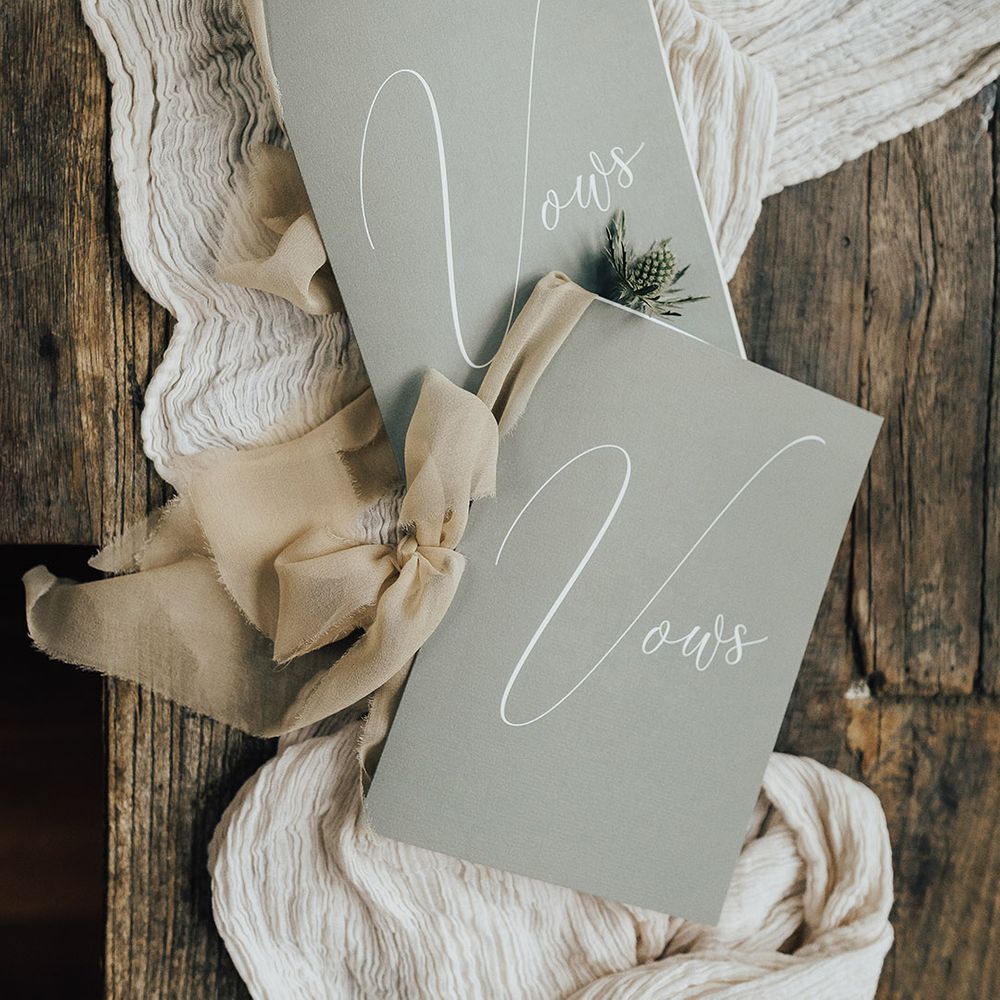 His and hers wedding vow books on a linen table runner 
