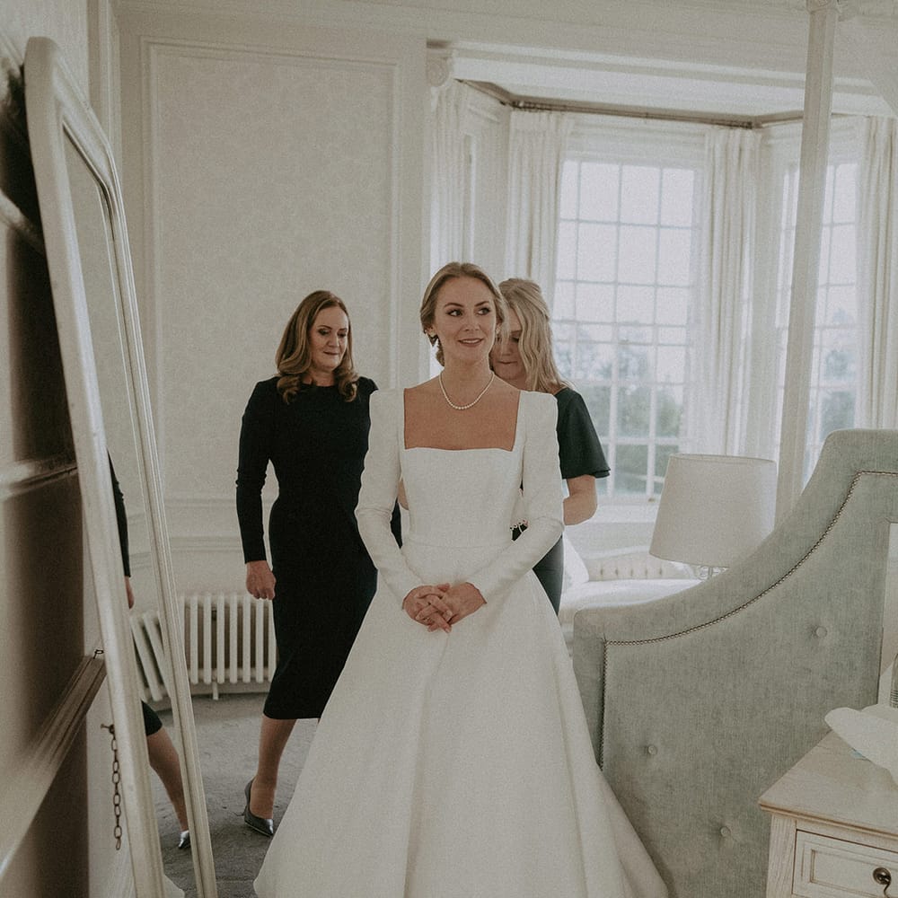 Bride in square neck, full skirt long wedding dress and pearl necklace at Hedsor House wedding