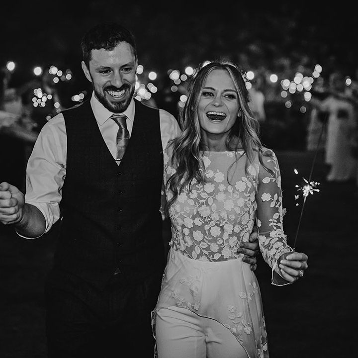 Bride in second reception look and groom have sparkler send off from their wedding 