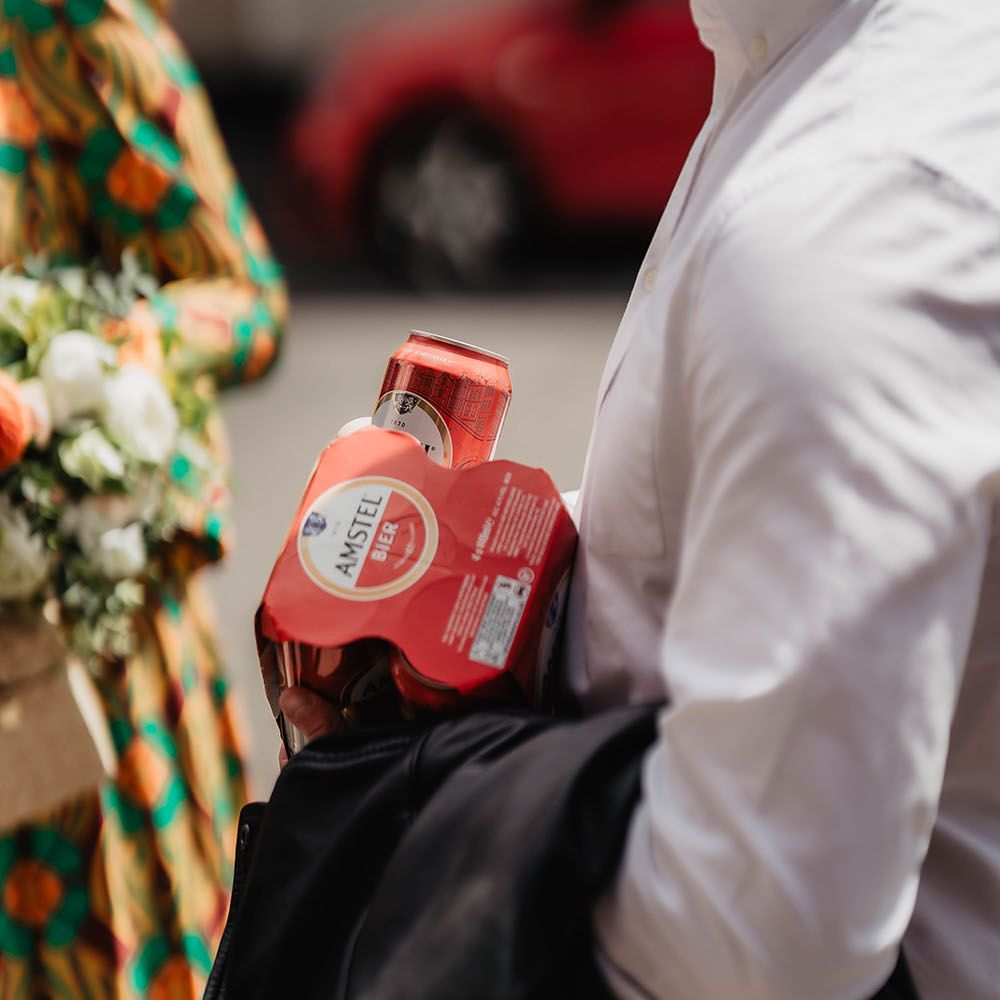 Wedding guest carries beer outdoors before wedding reception 