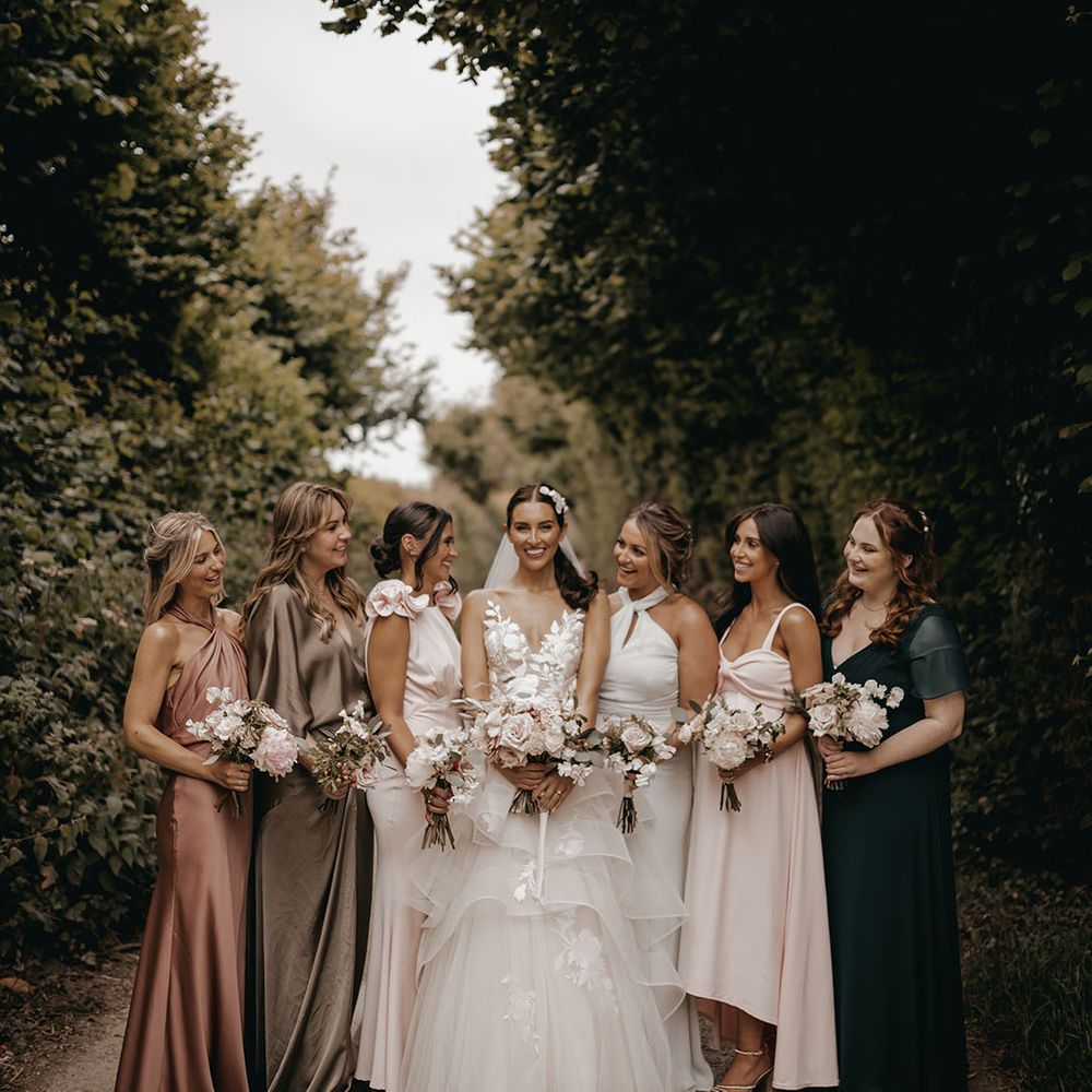 Bride in a Wtoo by Watters wedding dress with the bridesmaids in mismatched dresses
