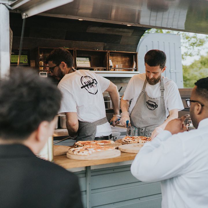 Pizza truck catering for outdoor wedding reception in tent