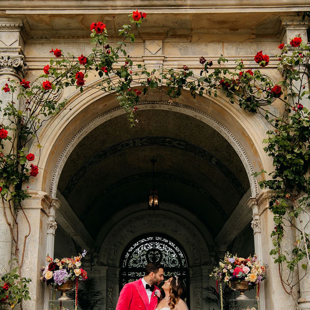 The bride in a tulle gown looks up into the groom's eyes as they stand together on their wedding day 