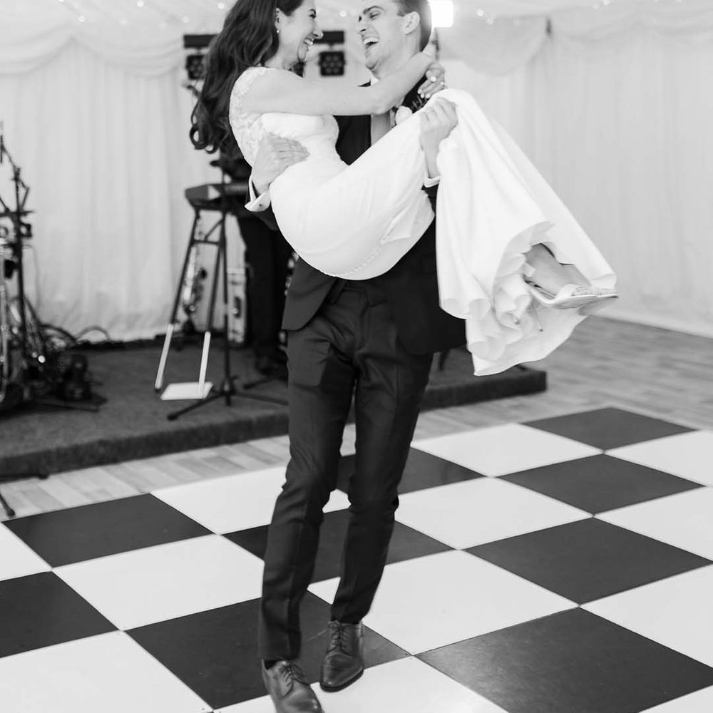 Bride and groom first dance on a black and white dance floor 