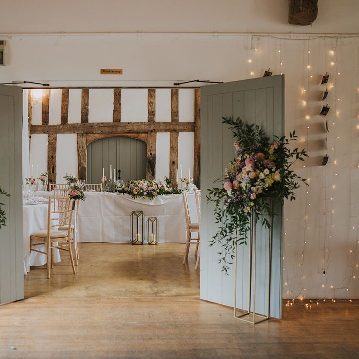 Dove Barn Weddings with the barn doors leading to the wedding reception decorated with pastel wedding flower arrangements 
