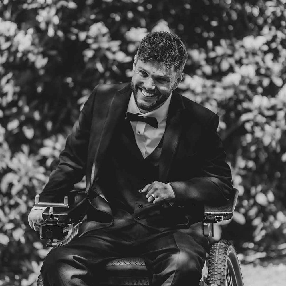 disabled groom in a wheelchair wearing a tuxedo 