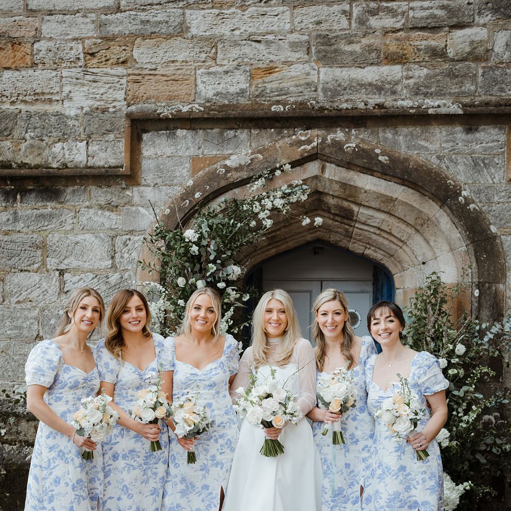 Bridesmaids in blue floral bridesmaid dresses with pastel and white wedding bouquets for spring wedding in Scotland 