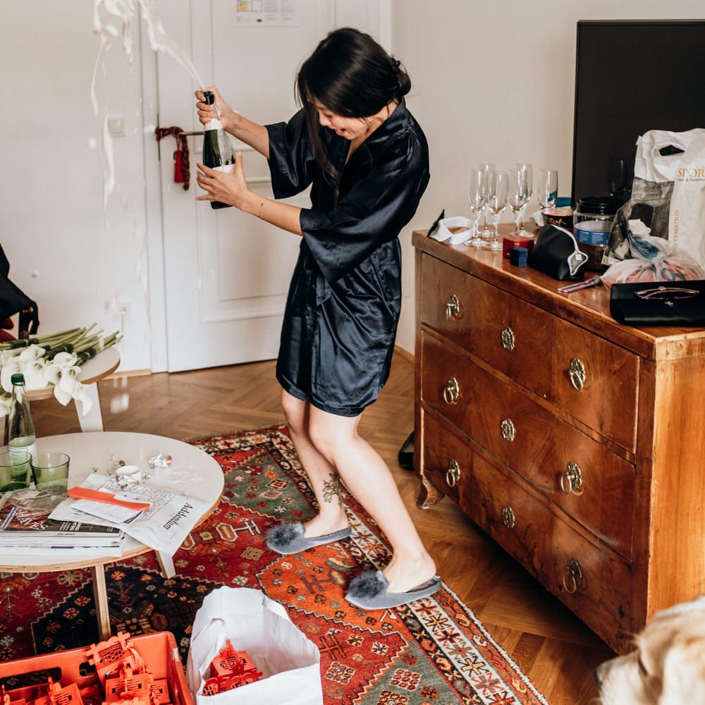 Bridesmaid popping champagne on the wedding morning 