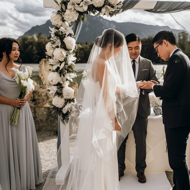 Bride and groom exchanging rings during the outdoor wedding ceremony 