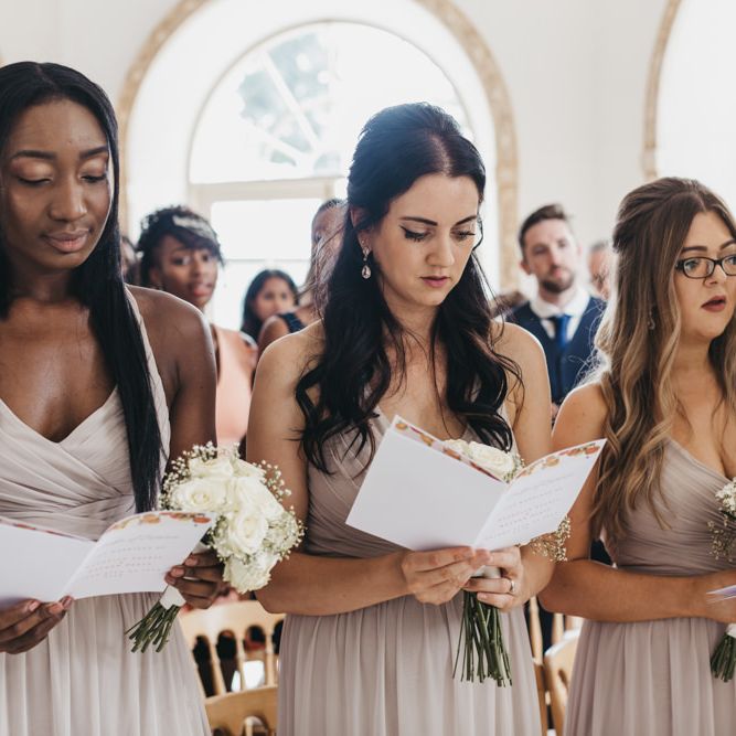Bridesmaids in beige chiffon dresses singing during the wedding ceremony 