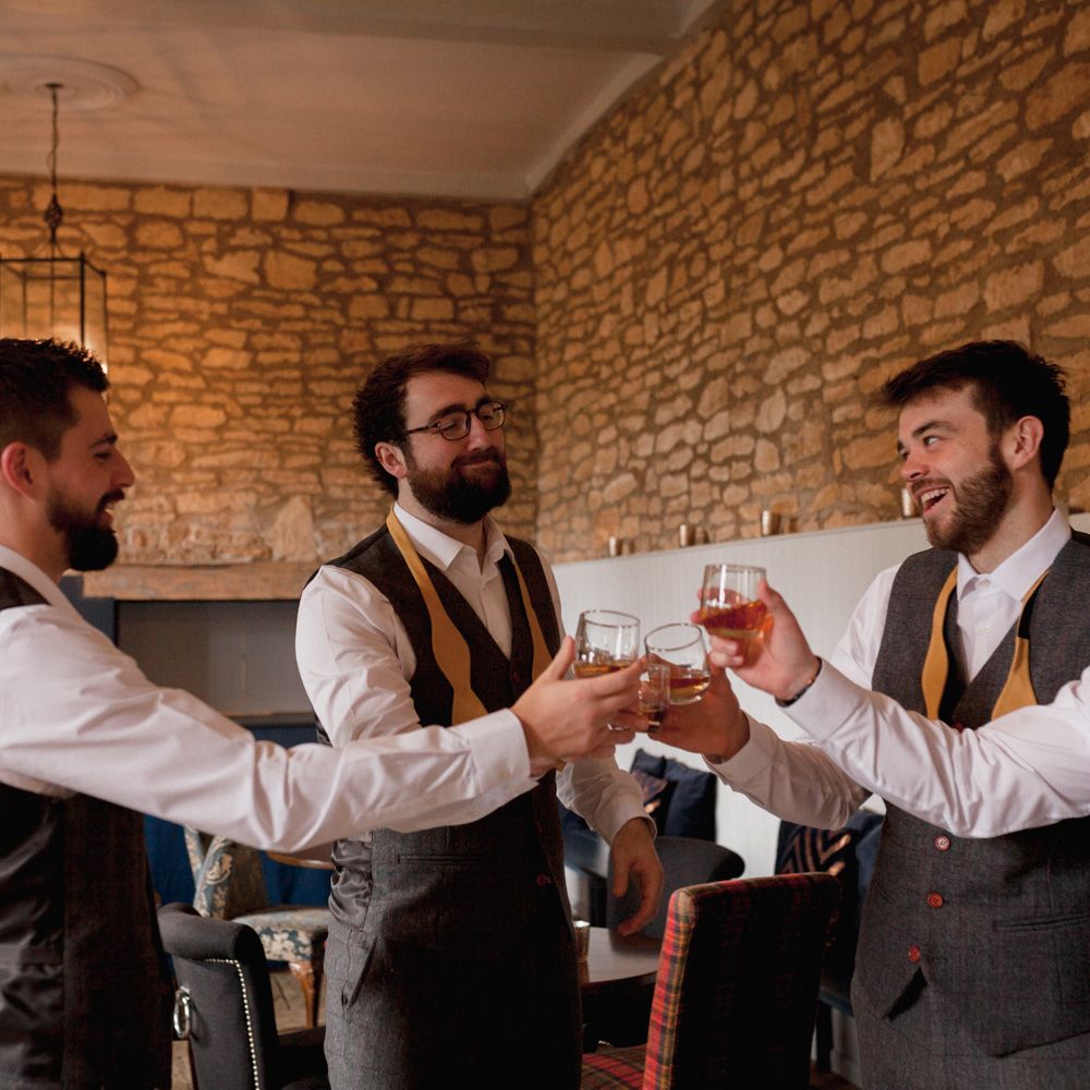 Groomsmen saying cheers on the morning of the wedding 