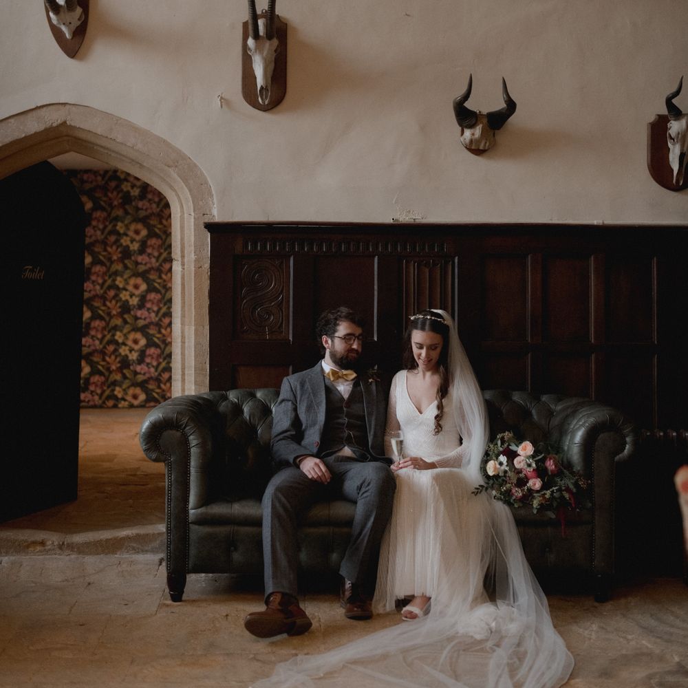 Bride and groom sat on black sofa at Brympton House Wedding 