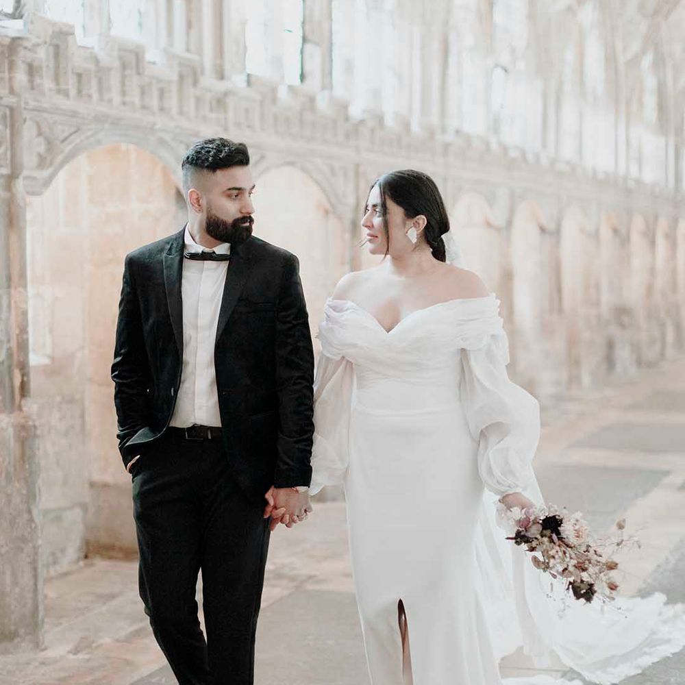 Elegant wedding at Blackfriars Priory with groom in a tuxedo and bride in an off the shoulder wedding dress with long sleeves 