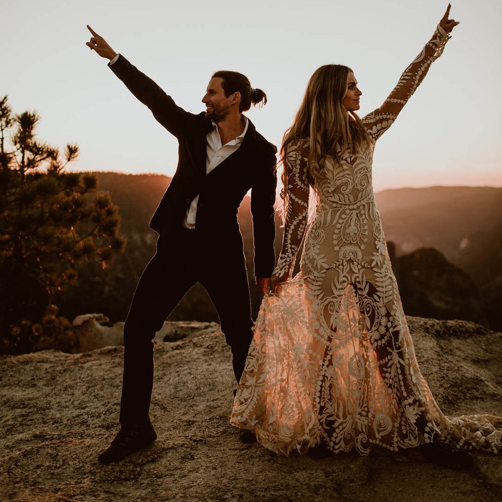Bride & groom lift their hands and arms in the air