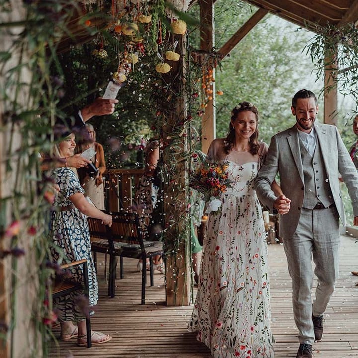 Bride and groom exit their wedding ceremony to confetti being thrown by wedding guests for botanical wedding 