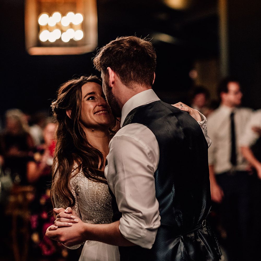 Bride and groom smile as they have their first dance together on their wedding day 