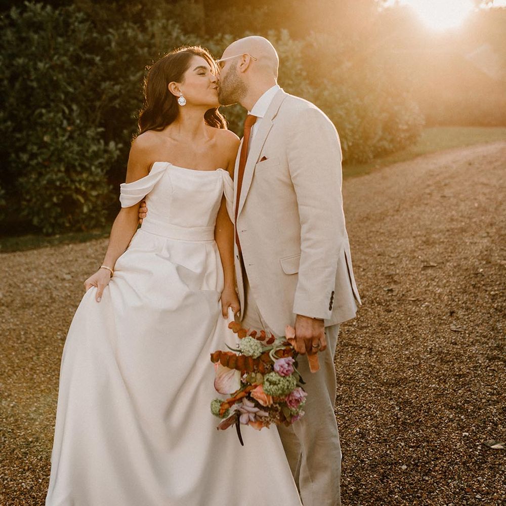 The sun starts setting and the golden light hits the bride and groom as they share a kiss 