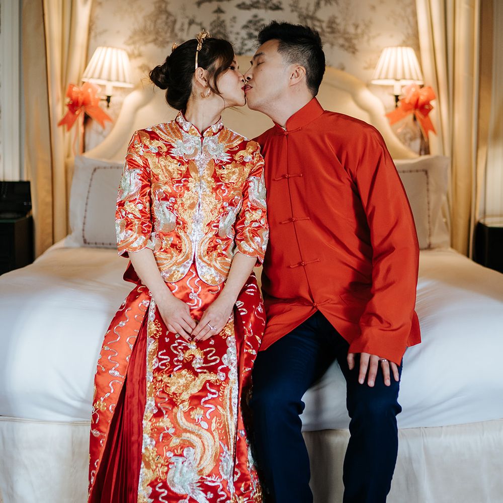 Bride & groom sit on bed at The Suite at The Dorchester after Chinese Tea Ceremony
