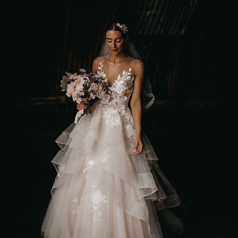 Bride in an illusion lace layered tulle wedding dress from Wtoo by Watters with a soft pink bouquet 