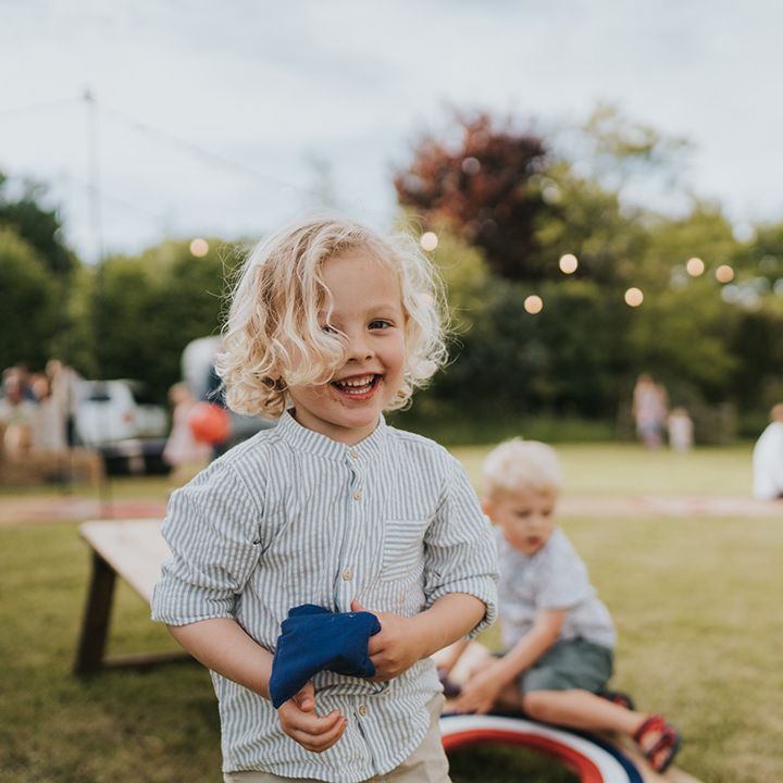 Little boy wears pale green striped shirt for outdoor wedding ceremony 