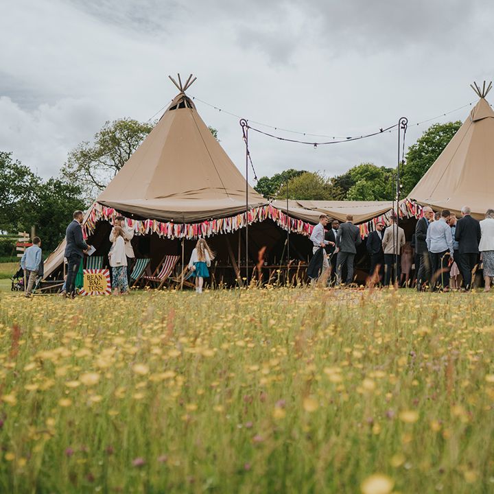Tent complete with colourful bunting for outdoor wedding reception at Burrow Farm Gardens 