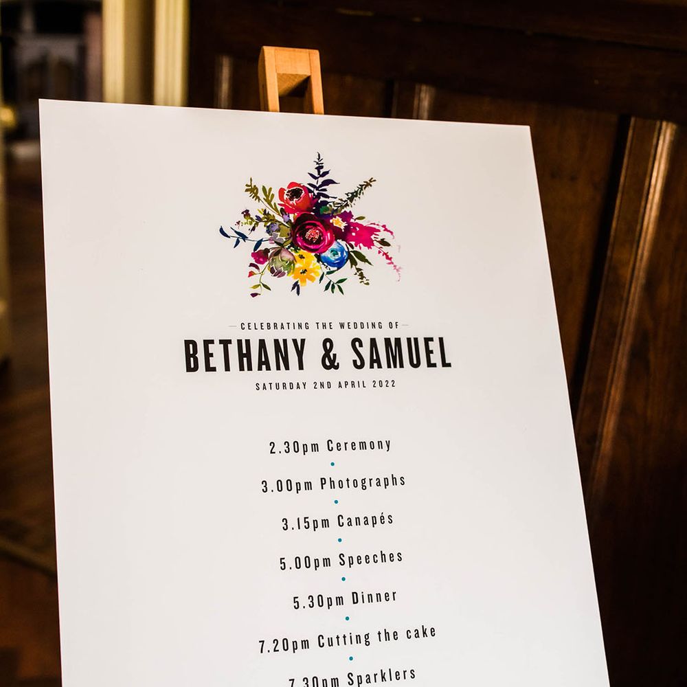 Order Of The Day wedding signage with colourful floral illustration on wooden easel 