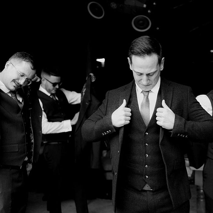 The groom and groomsmen all get ready and dressed for the wedding day wearing wedding outfits with burnt orange theme 
