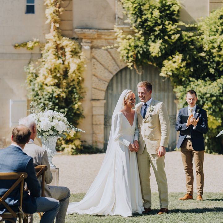 Bride in a floaty wedding dress and groom in a beige suit at Château de Malliac, French destination wedding 