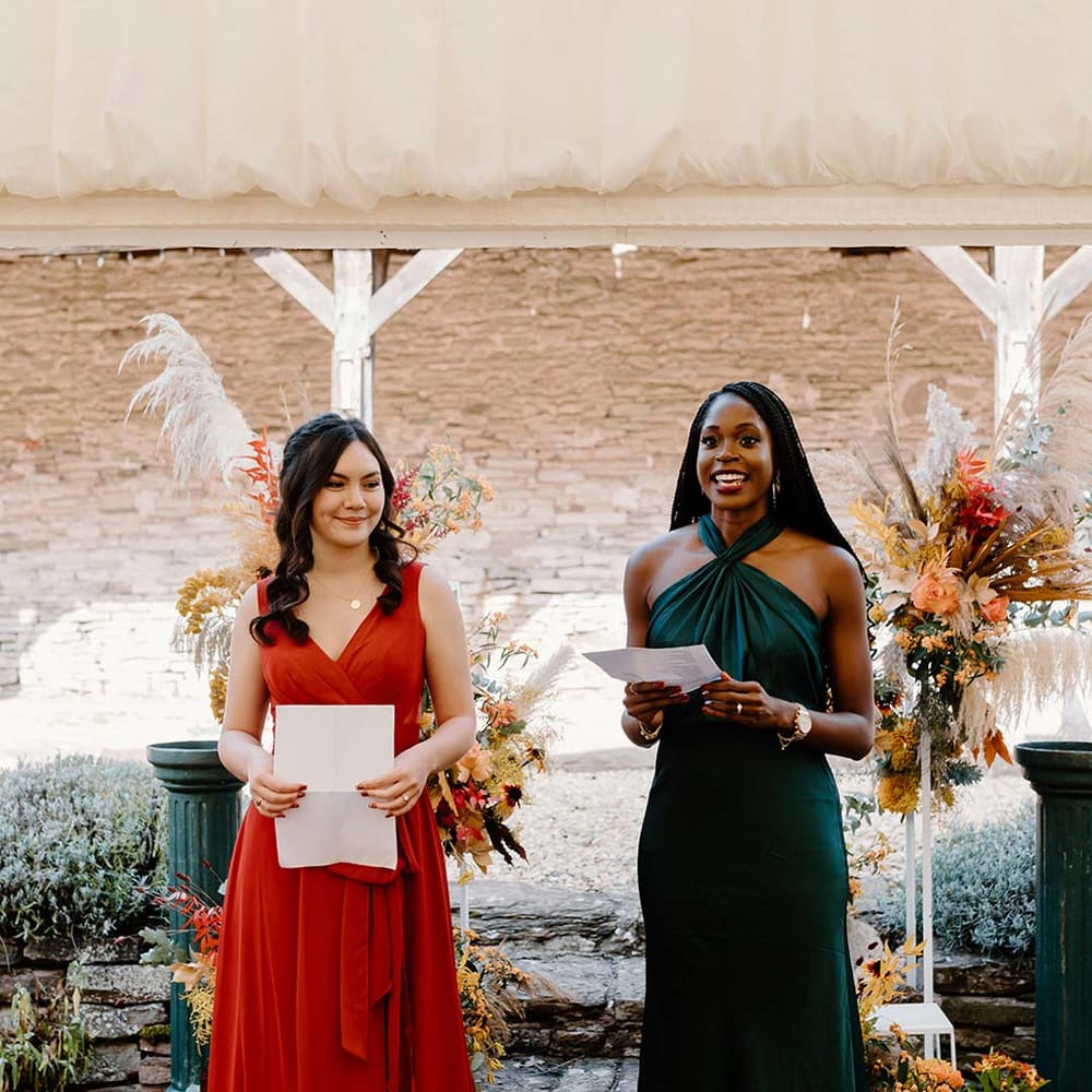 Bridesmaids in mismatched bridesmaid dresses at the alter of Broadfield Court doing bridesmaid speeches