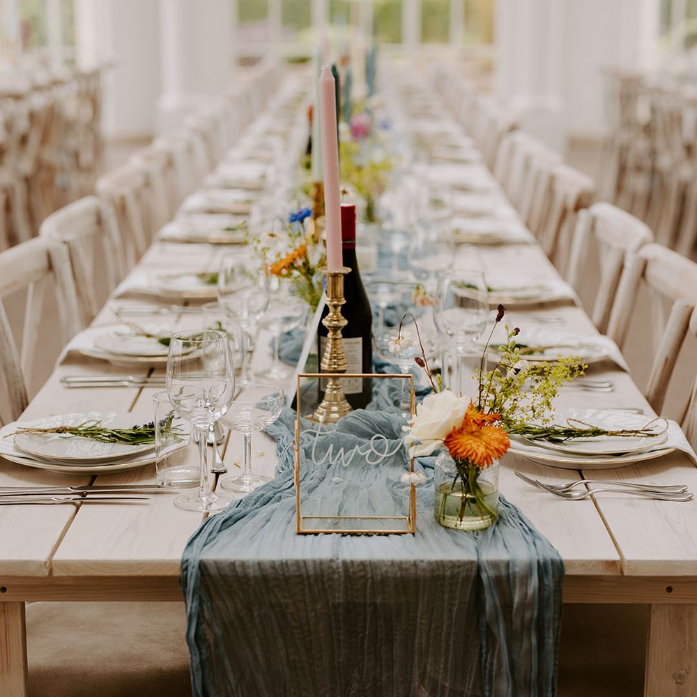 Dusty blue wedding theme table decor with pastel candles for coastal summer wedding 