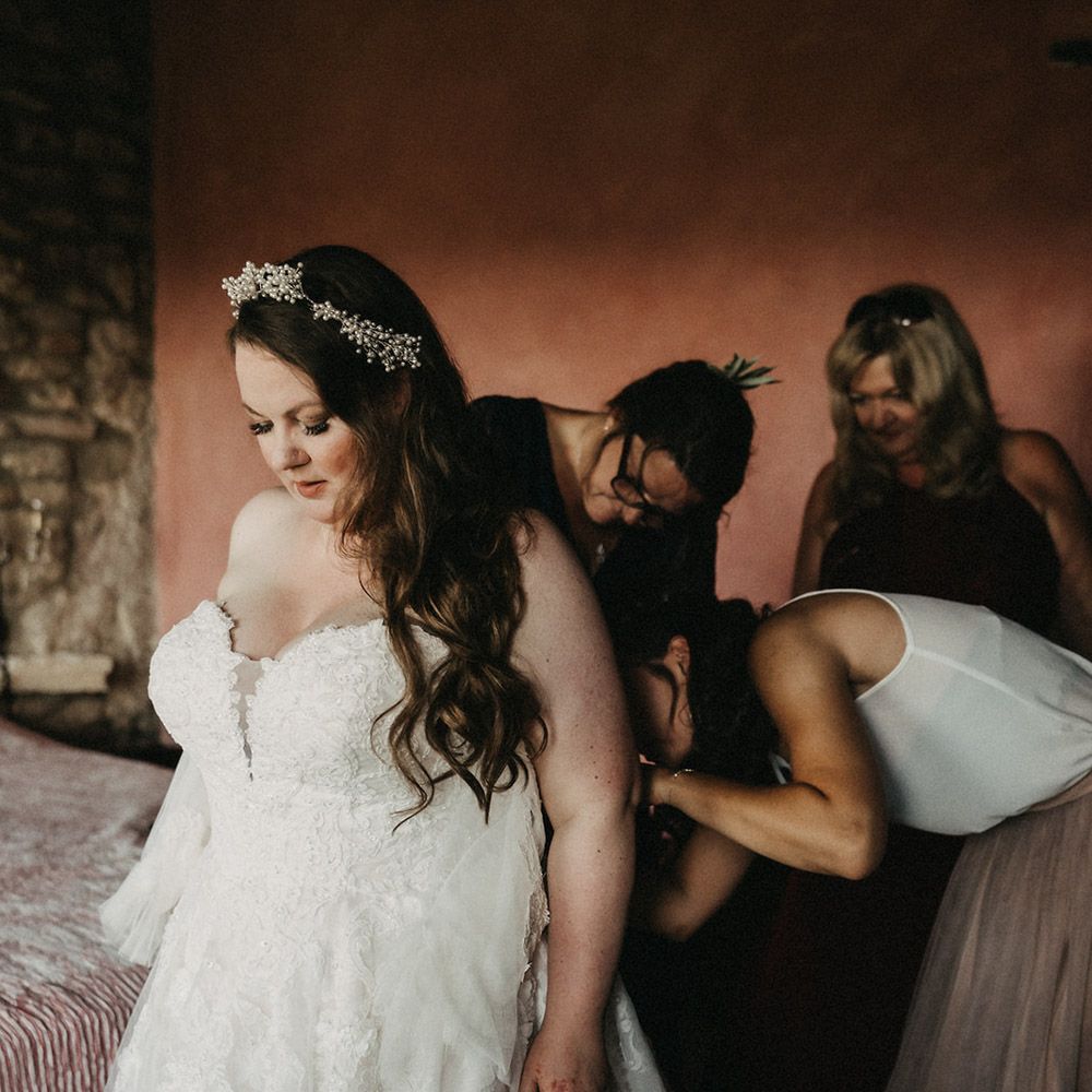 Bridesmaids helping Saskia get into her dress
