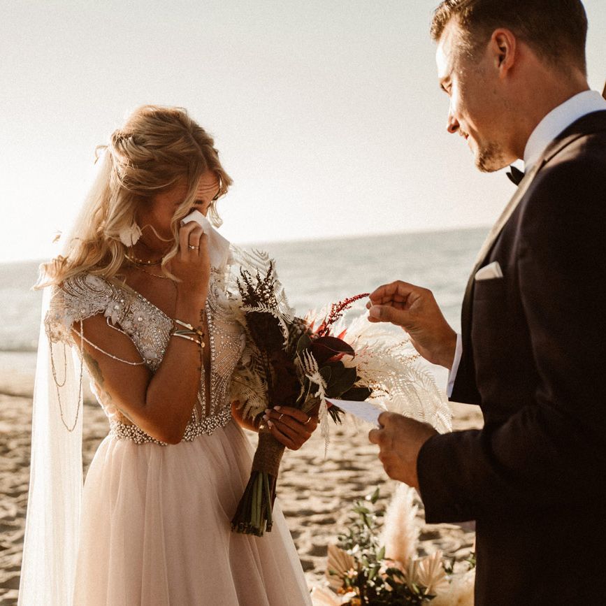 Bride wipes a tear form her eye during wedding cereemony