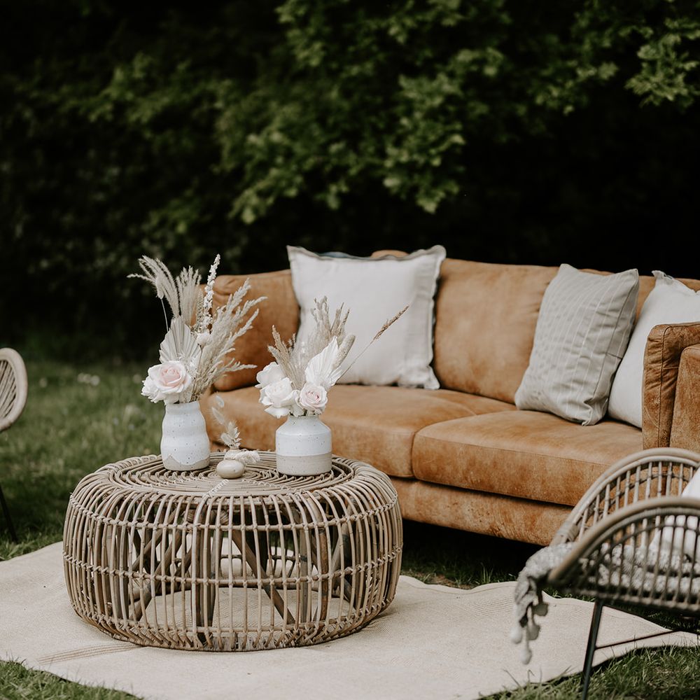 Outdoor seating area with rug, bamboo furniture and dried flower arrangements 