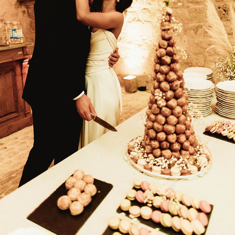 Bride & groom kiss in front croquembouche