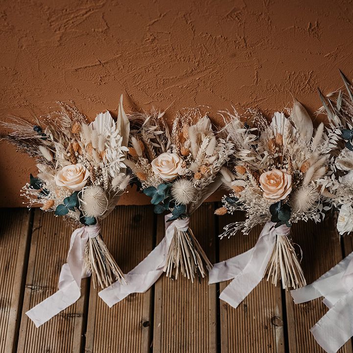 Dried florals complete with roses and pampas grass tied with white ribbon