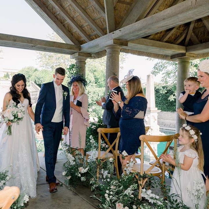 Bride & groom hold hands as they walk together on their wedding day