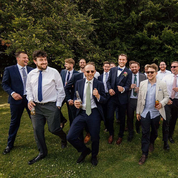 Groom in three piece blue suit with blue bow tie with all the men as part of the wedding party 