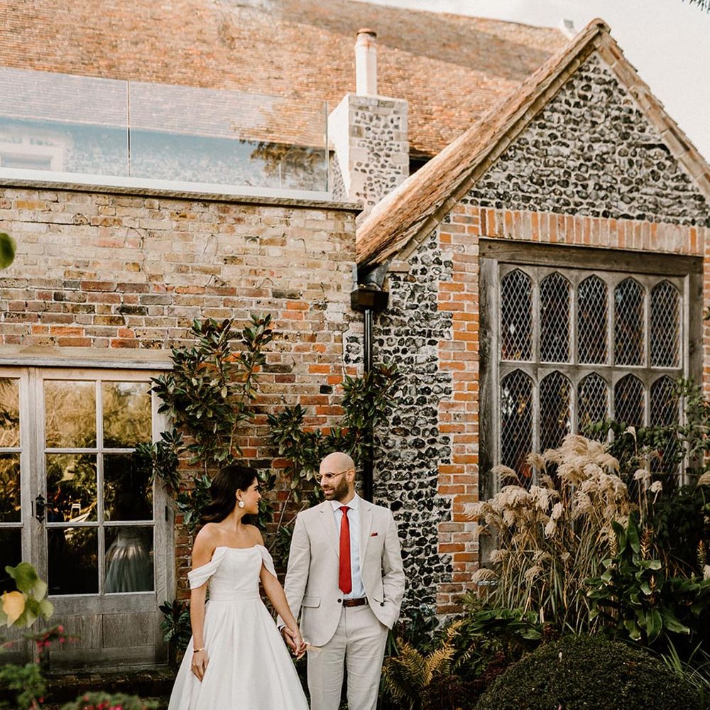 Bride and groom look into each other's eyes as they stand outside the Chapel House Estate wedding venue 