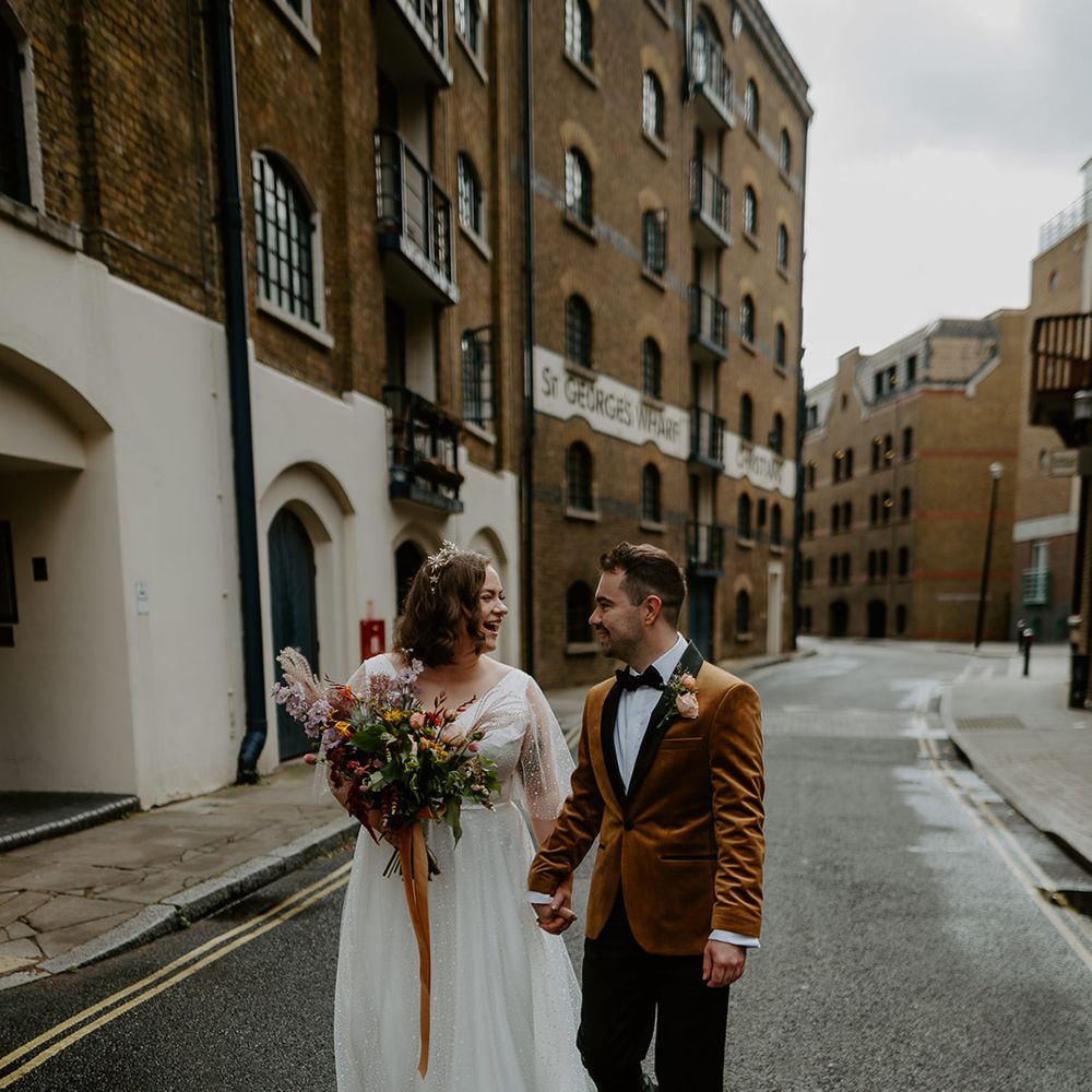 Bride and Groom hold hands and walk through the streets at London Wedding