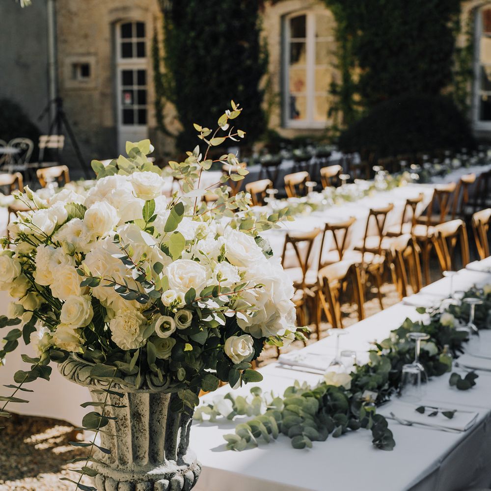 white wedding flowers and green foliage floral arrangement at outdoor wedding reception 