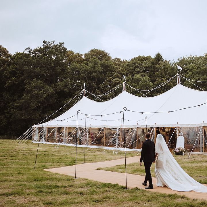 Bride and groom walking on the way to their marquee reception in Lincolnshire 