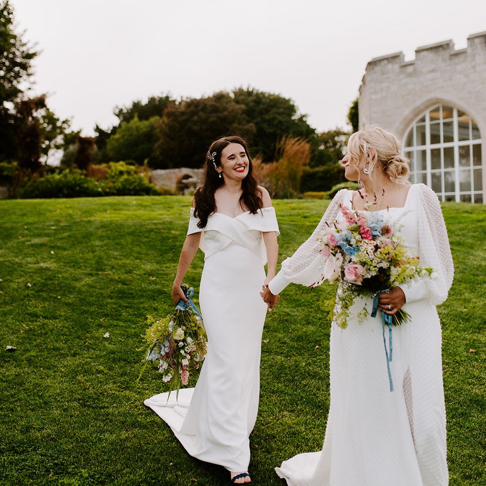 Brides walking hand in hand at castle wedding venue 
