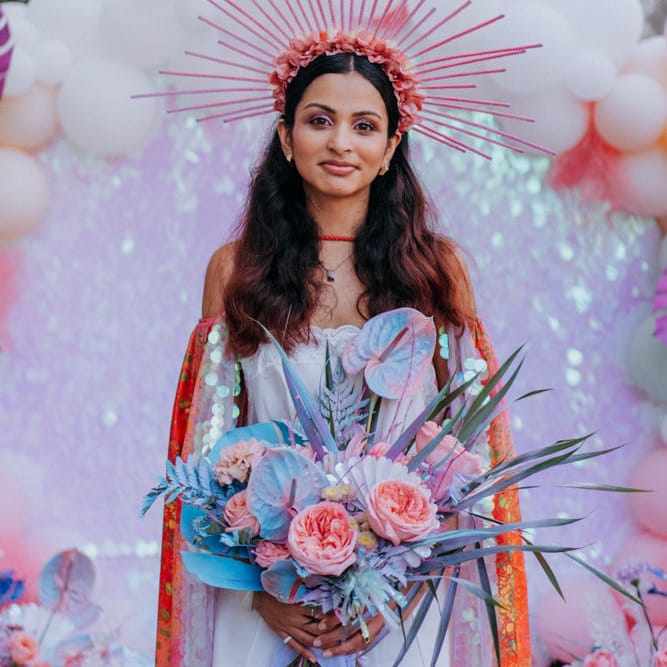 Stylish bride at festival inspired wedding with crown, cape and boots