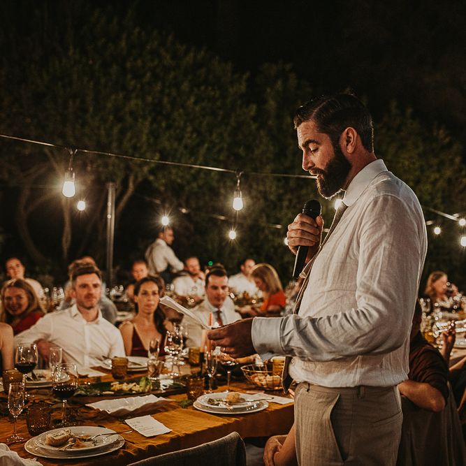 Groom delivering the speech at outdoor wedding 